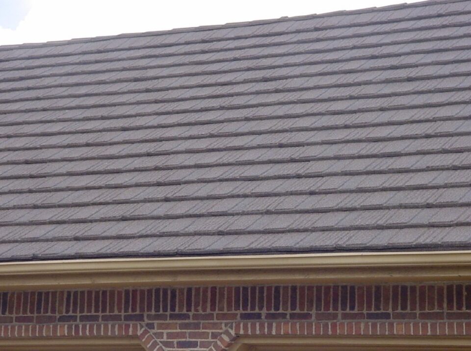 Gray shingle roof on a brick house with a gutter along the edge in Santa Clara